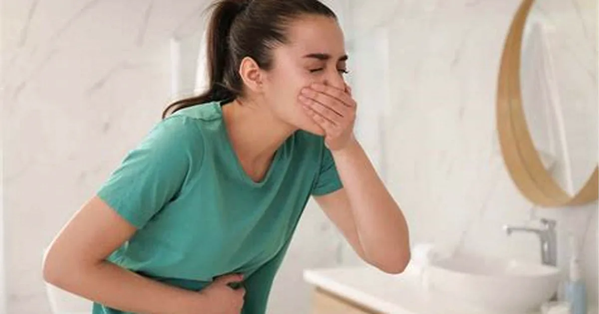Person feeling queasy and holding their stomach, wondering if Tylenol helps with nausea