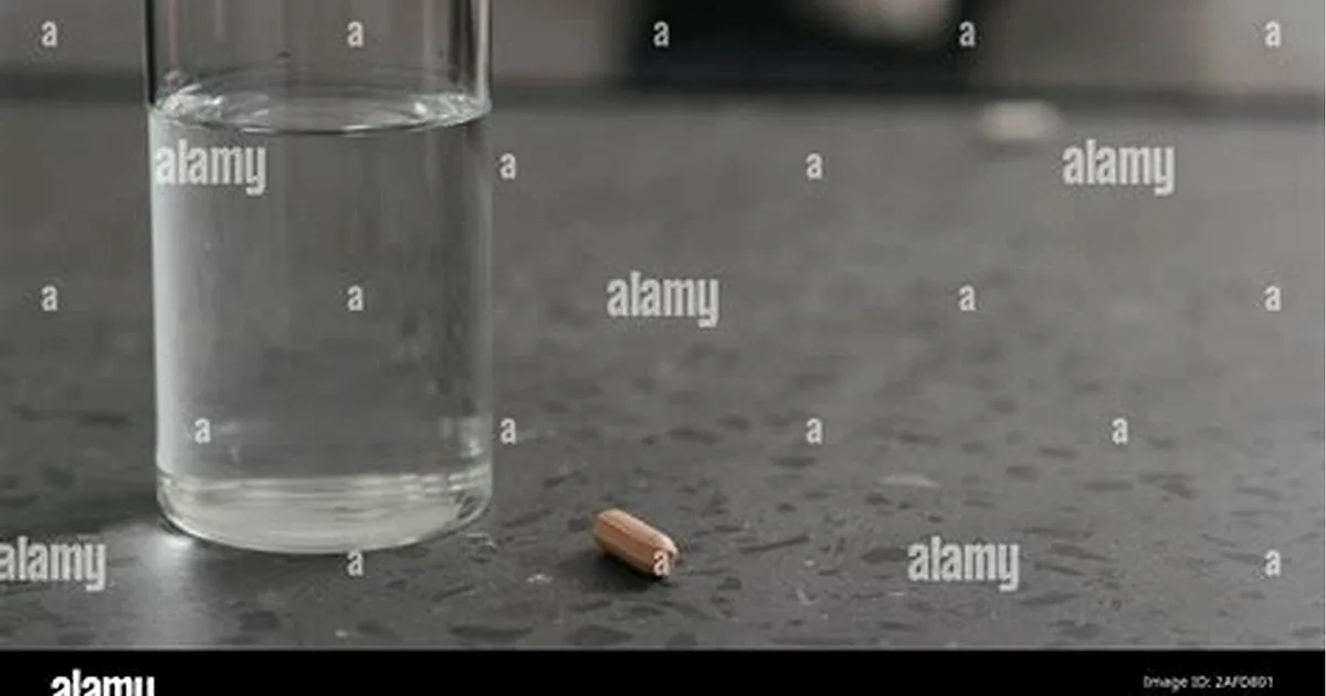 A Tylenol acetaminophen tablet and a glass of water, illustrating whether you can take Tylenol on an empty stomach